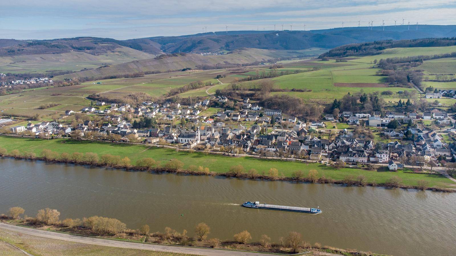 Aerial view of the river Moselle valley with cargo ship and the village Brauneberg 