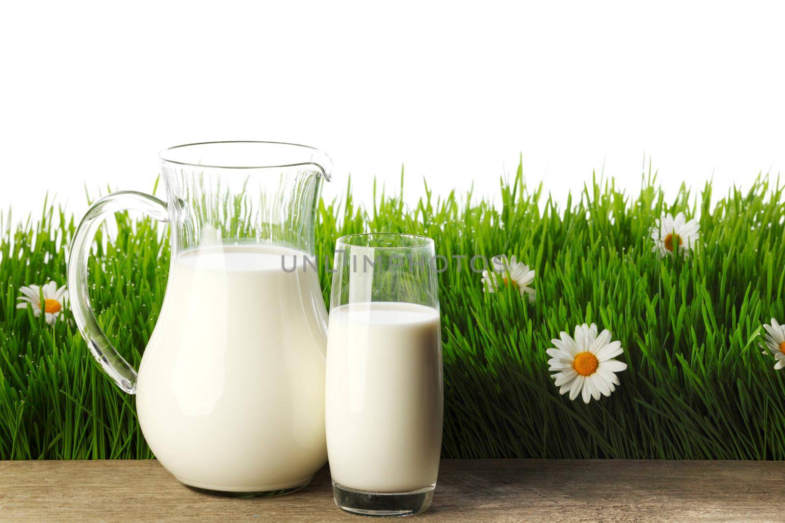 Milk jug and glass on flower field by Yellowj