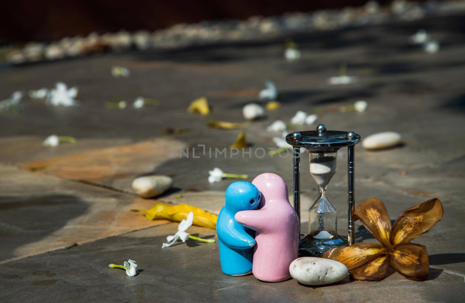 Blue and pink ceramic couple dolls hug with each other on stone background. Concept for anniversary, Wedding and eternal love concept, Romance wedding or Valentine’s day.