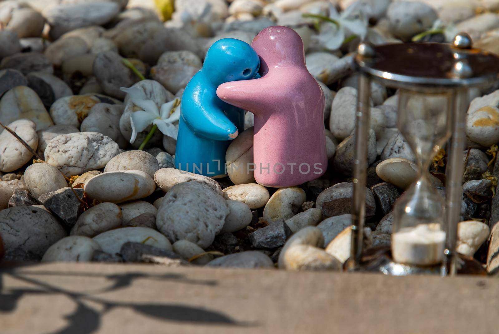 Blue and pink ceramic couple dolls hug with each other on stone background. Concept for anniversary, Wedding and eternal love concept, Romance wedding or Valentine’s day.
