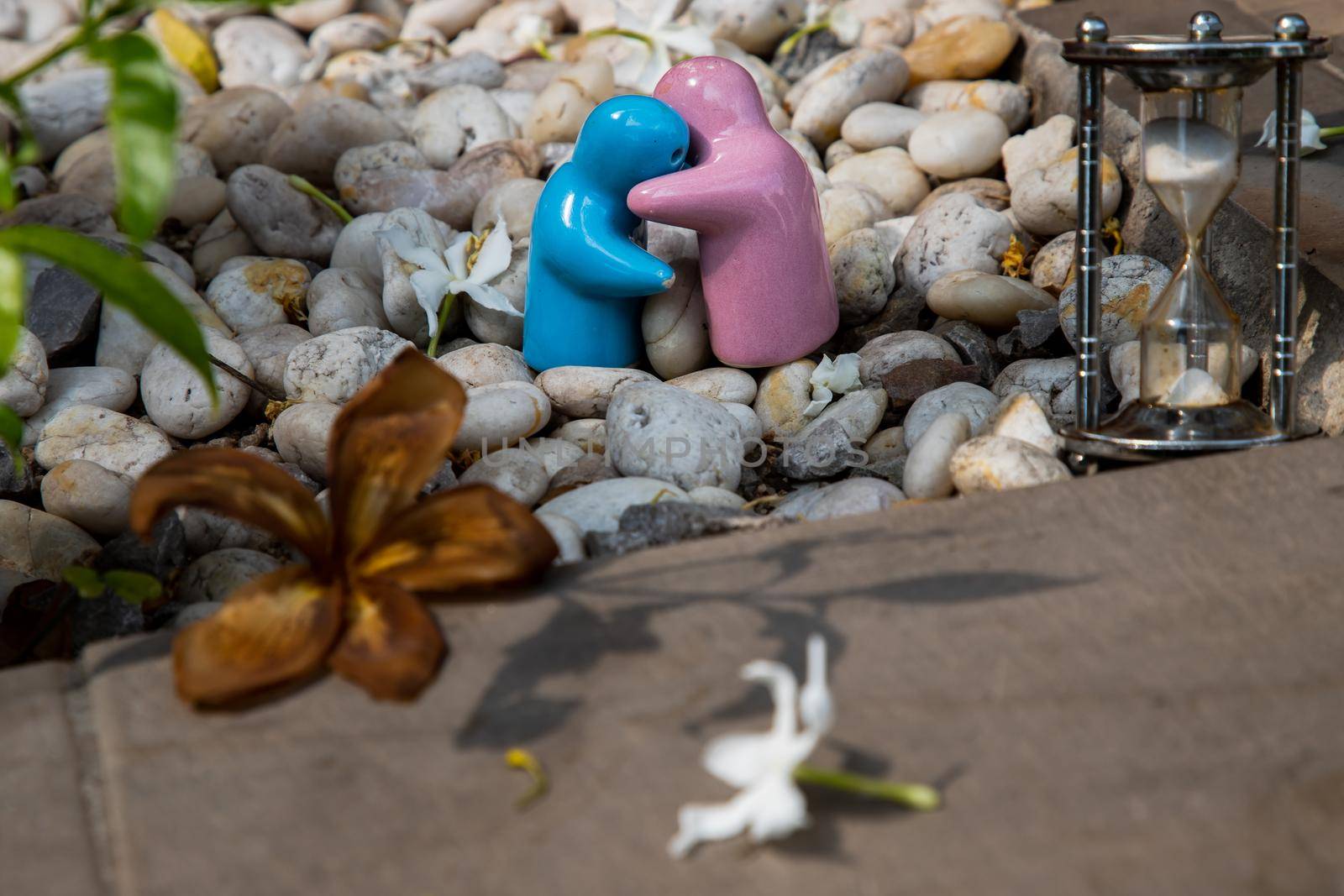 Blue and pink ceramic couple dolls hug with each other on stone background. Concept for anniversary, Wedding and eternal love concept, Romance wedding or Valentine’s day.
