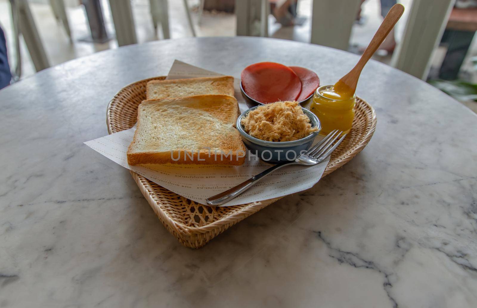 Traditional thai sandwich with slices of toast bread, Bologna sausage and Shredded pork, Homemade sweet mayonnaise in Wicker tray. Thai language written on Food parchment Translated into English as "Traditional sandwiches 2563" Sandwich thai style. No focus, specifically.