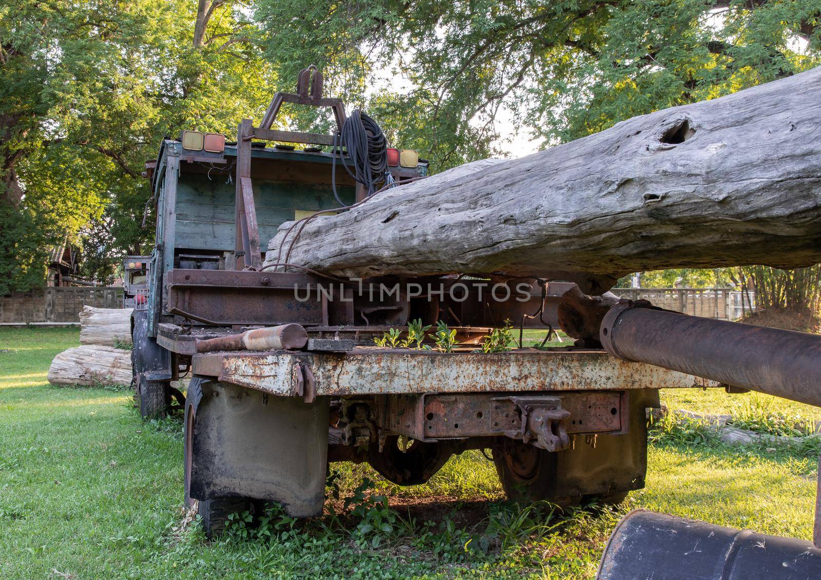 Old Logging truck with wooden logs on old traditional farm area. Abandoned car, Selective focus.