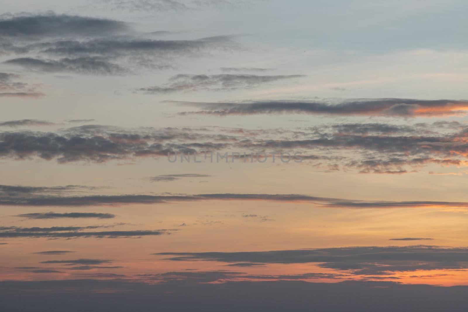 Scenic Colorful Sky At Sunset. Light blue clouds and orange on background, The softness of the cloud creates a feeling of relaxation. Copy space. No focus, specifically.