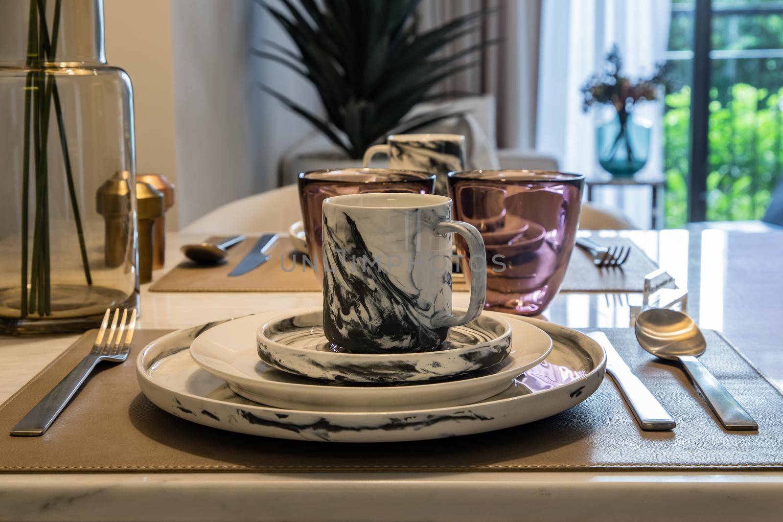 Dining table with vase of flower on marble table in home dining room. Interior design concept.
