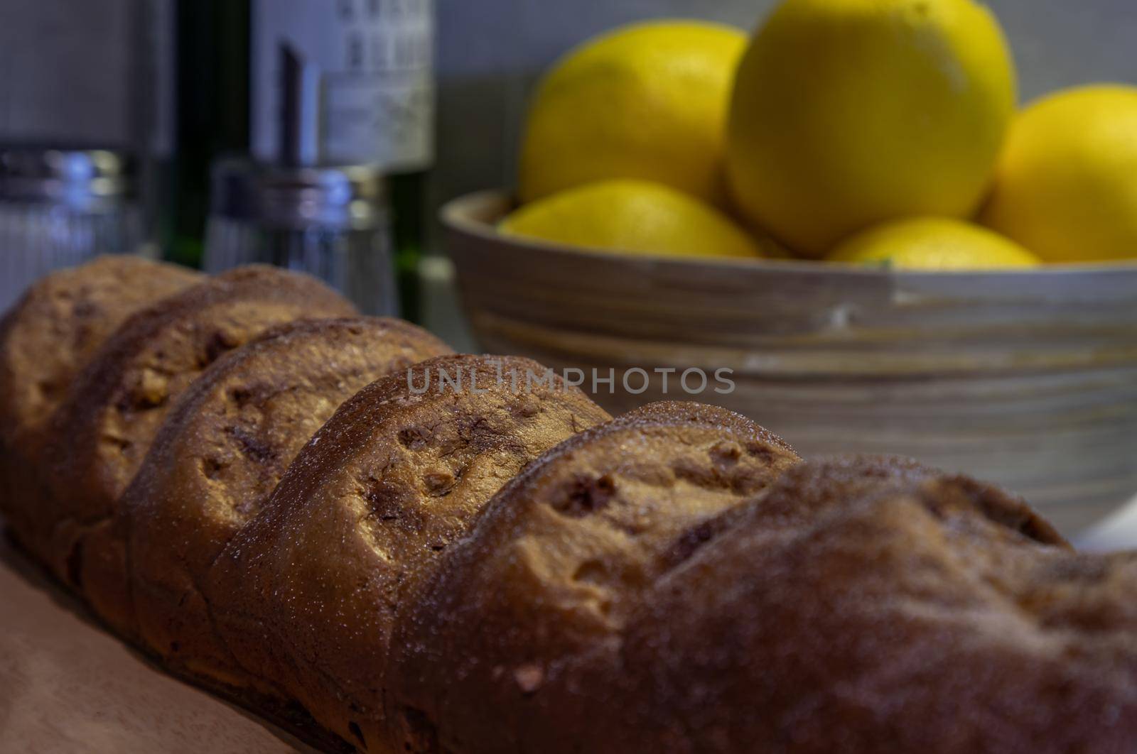 Close-up of French Baguette and lemons on kitchen table. Selective focus.