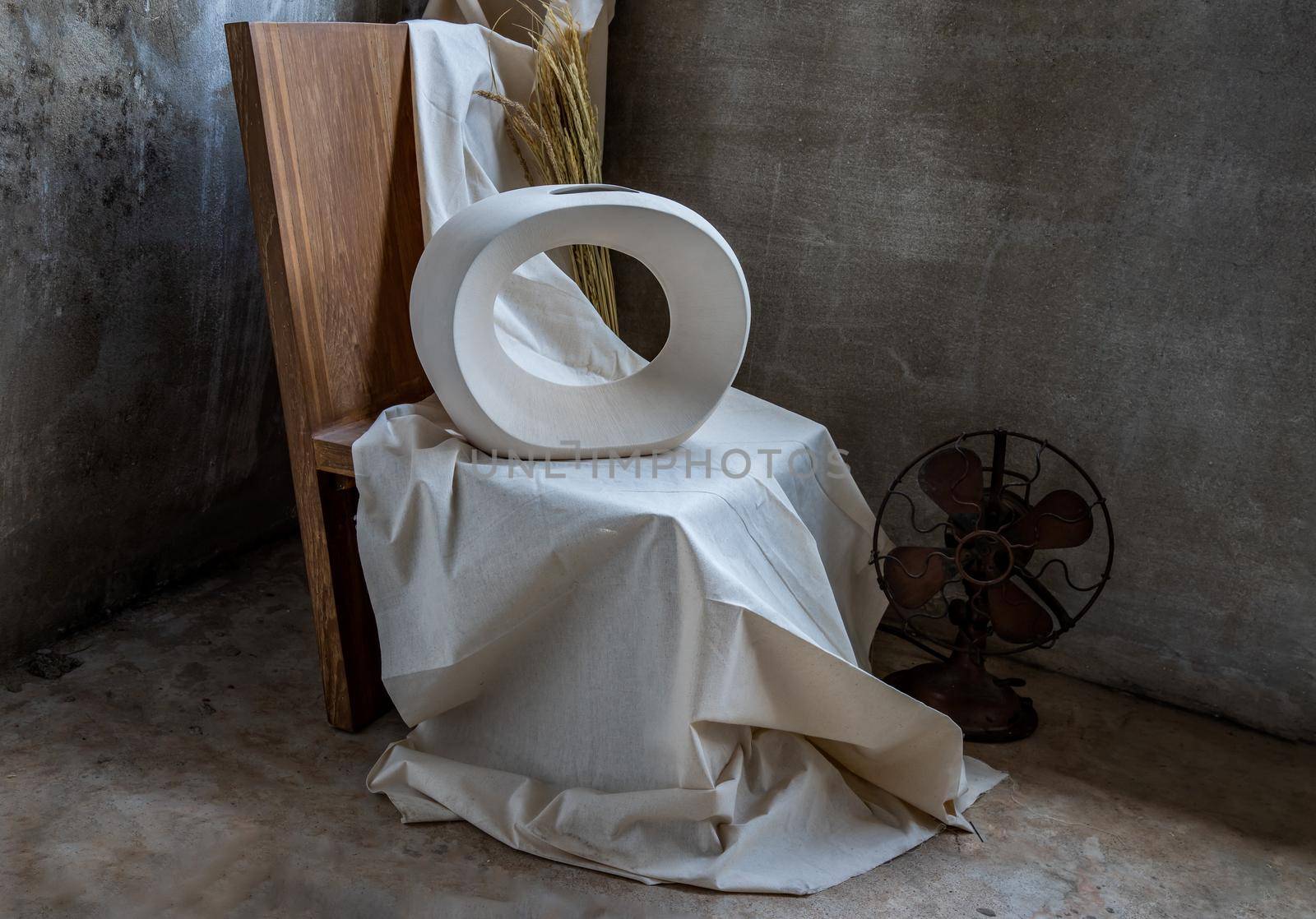 Beautiful ceramic white vase handmade on wooden chair. Home decor, Space for text.