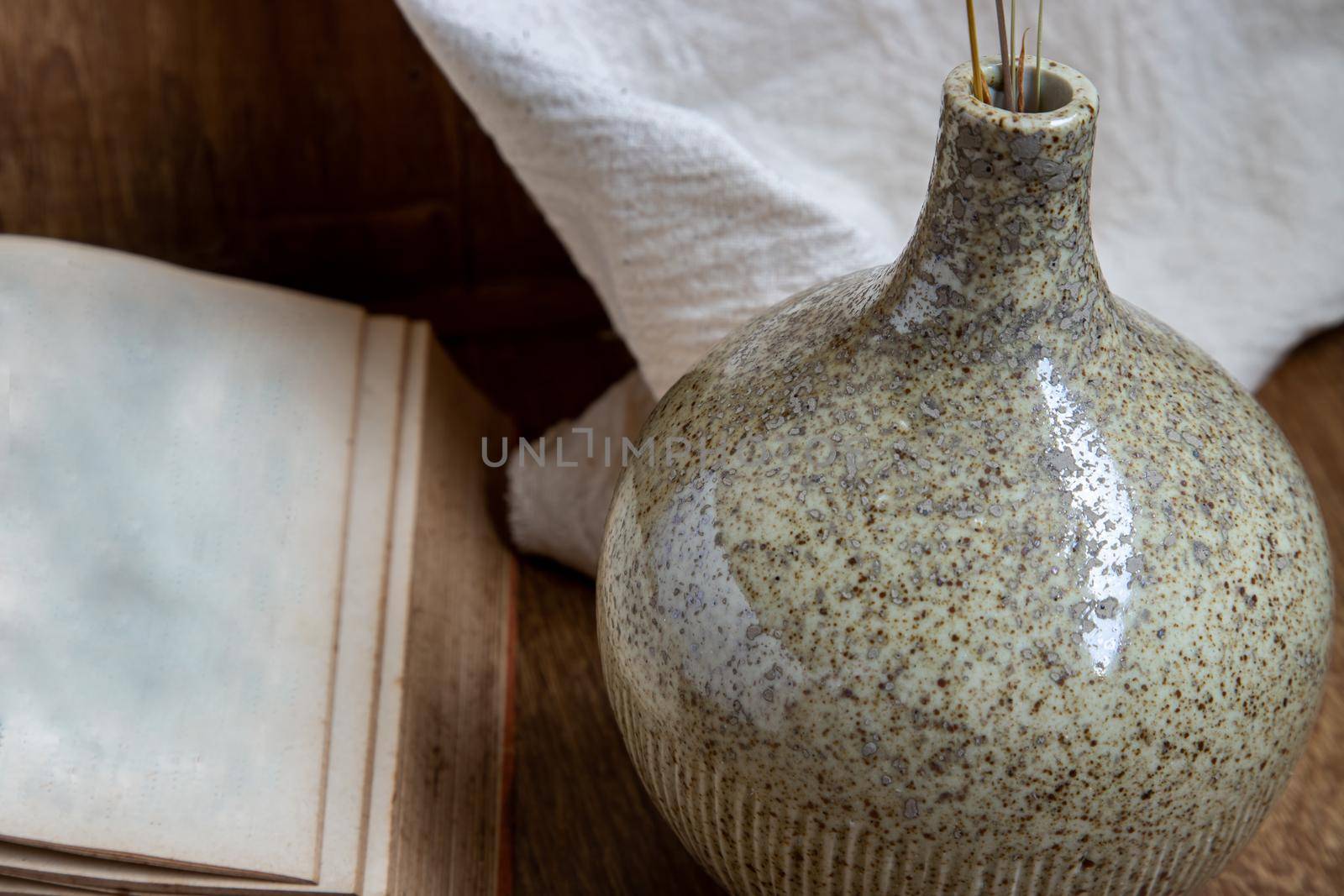 Handmade ceramic vases and book on wooden background. Home decoration, space for text.