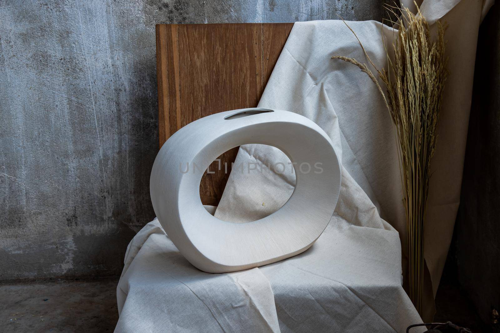 Beautiful ceramic white vase handmade on wooden chair. Home decor, Space for text.