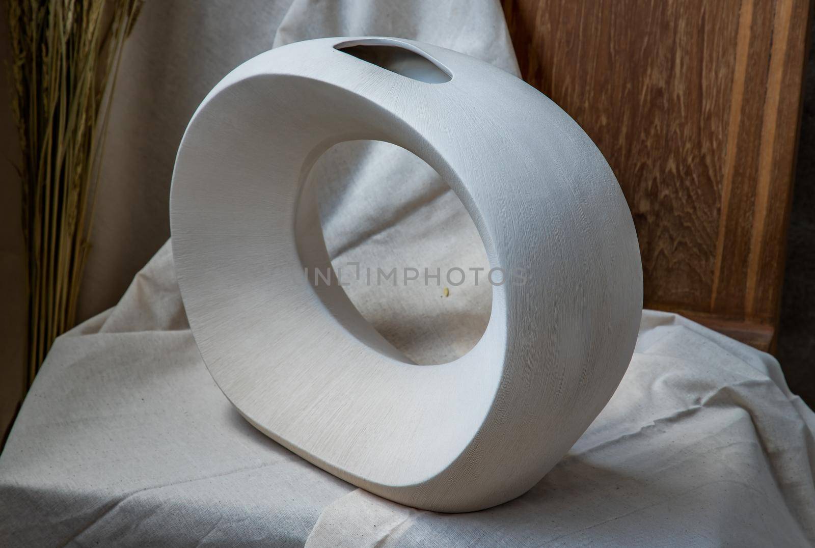 Beautiful ceramic white vase handmade on wooden chair. Home decor, Space for text.