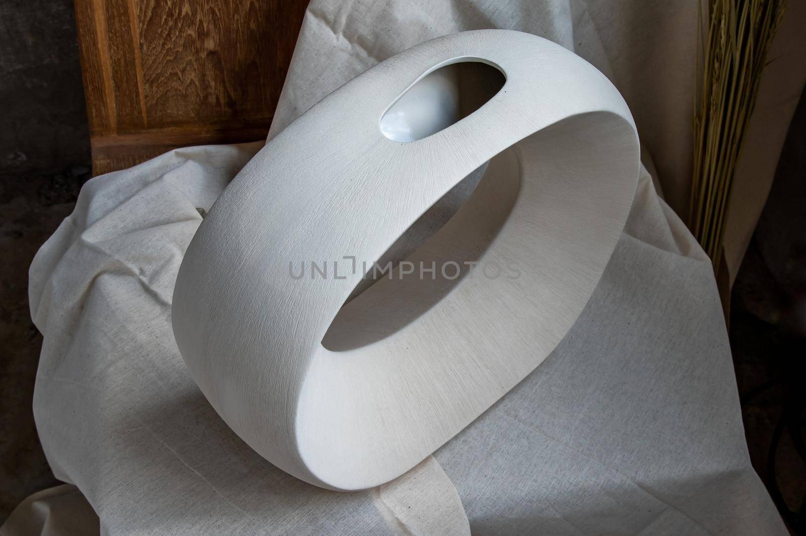 Beautiful ceramic white vase handmade on wooden chair. Home decor, Space for text.