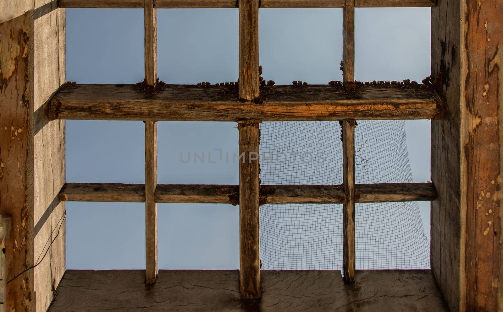 The old wooden battens roof structure of the outdoor vegetable garden. Selective focus.