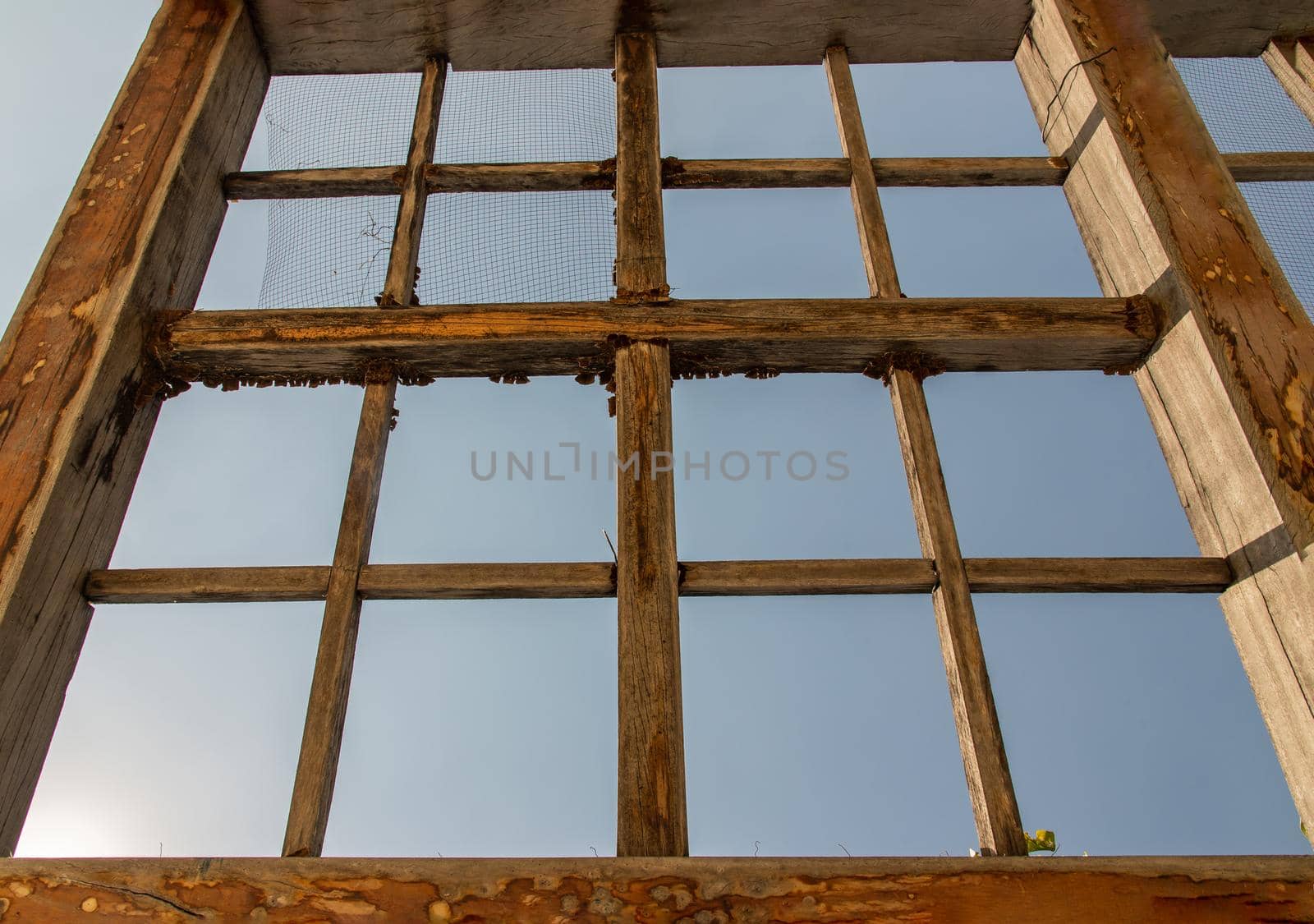 The old wooden battens roof structure of the outdoor vegetable garden. Selective focus.