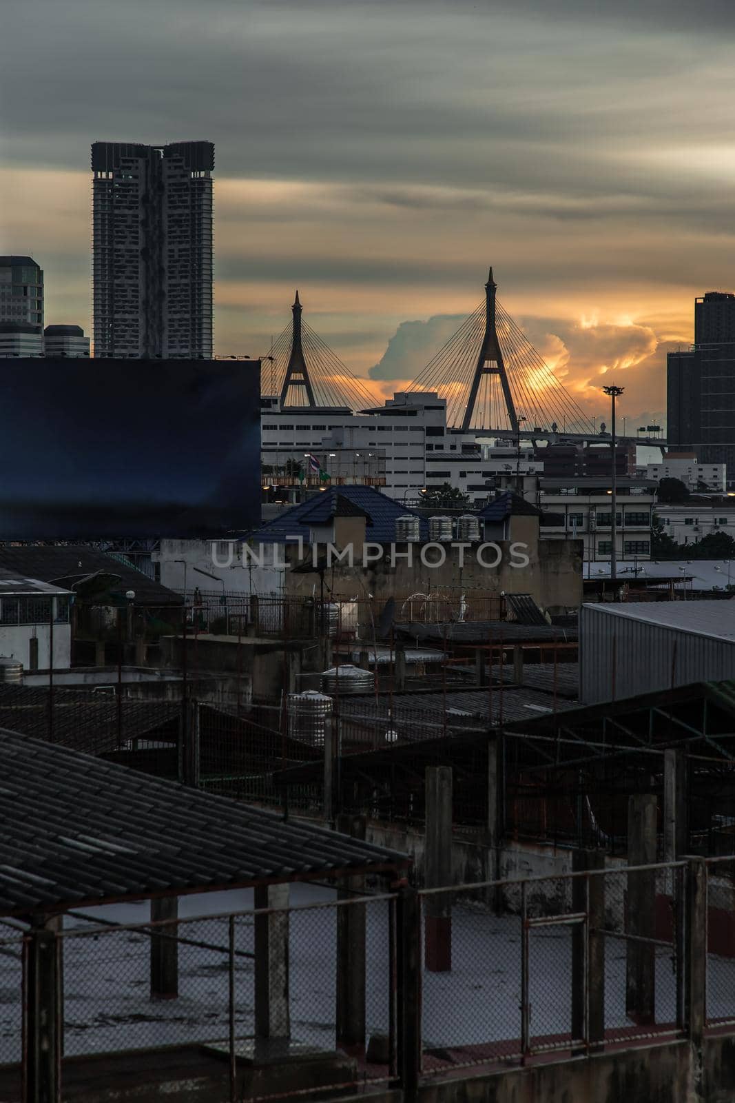 View of Bhumibol suspension bridge cross over Chao Phraya River in Bangkok city at beautiful sunset sky and clouds in Bangkok Thailand.