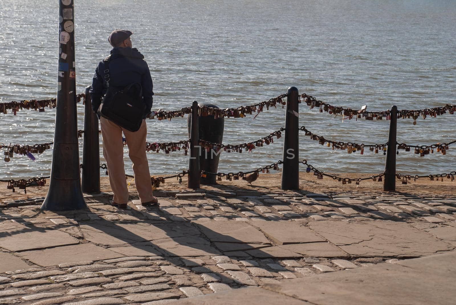 Liverpool, United Kingdom - 03 Jan 2019 : The back of Lonely young man standing on the river walk and looking at skyline. No focus, specifically.