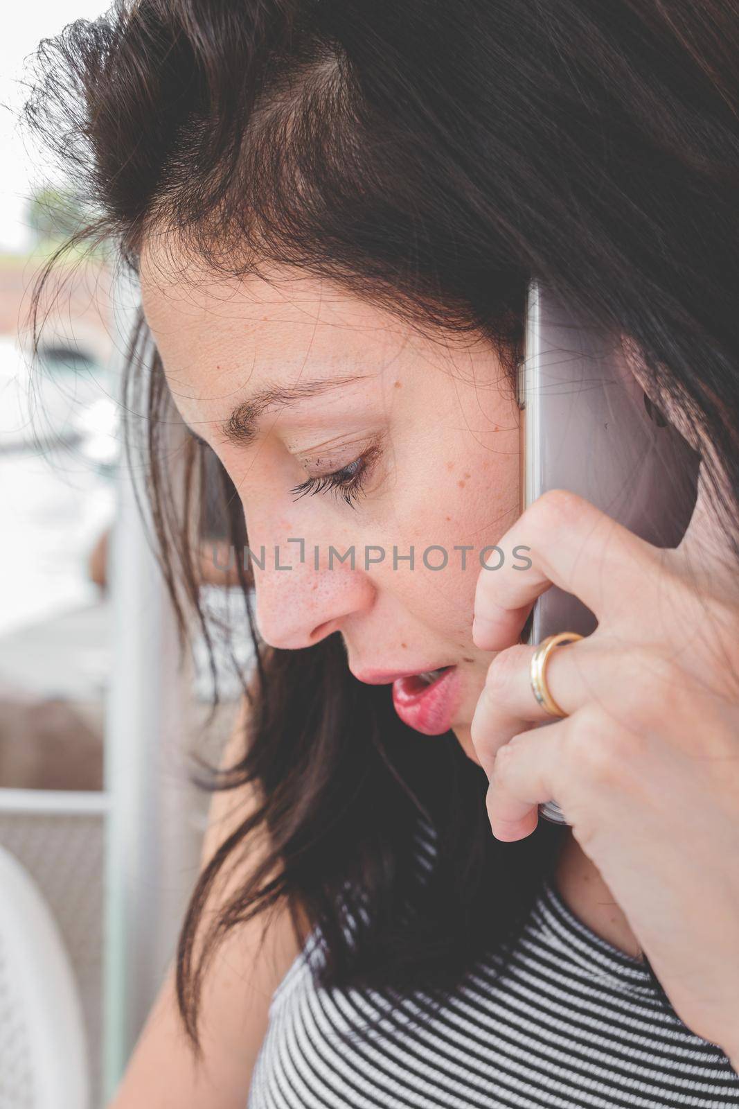 Brunette girl with a striped t-shirt talk on the cell phone. Retro style photo.