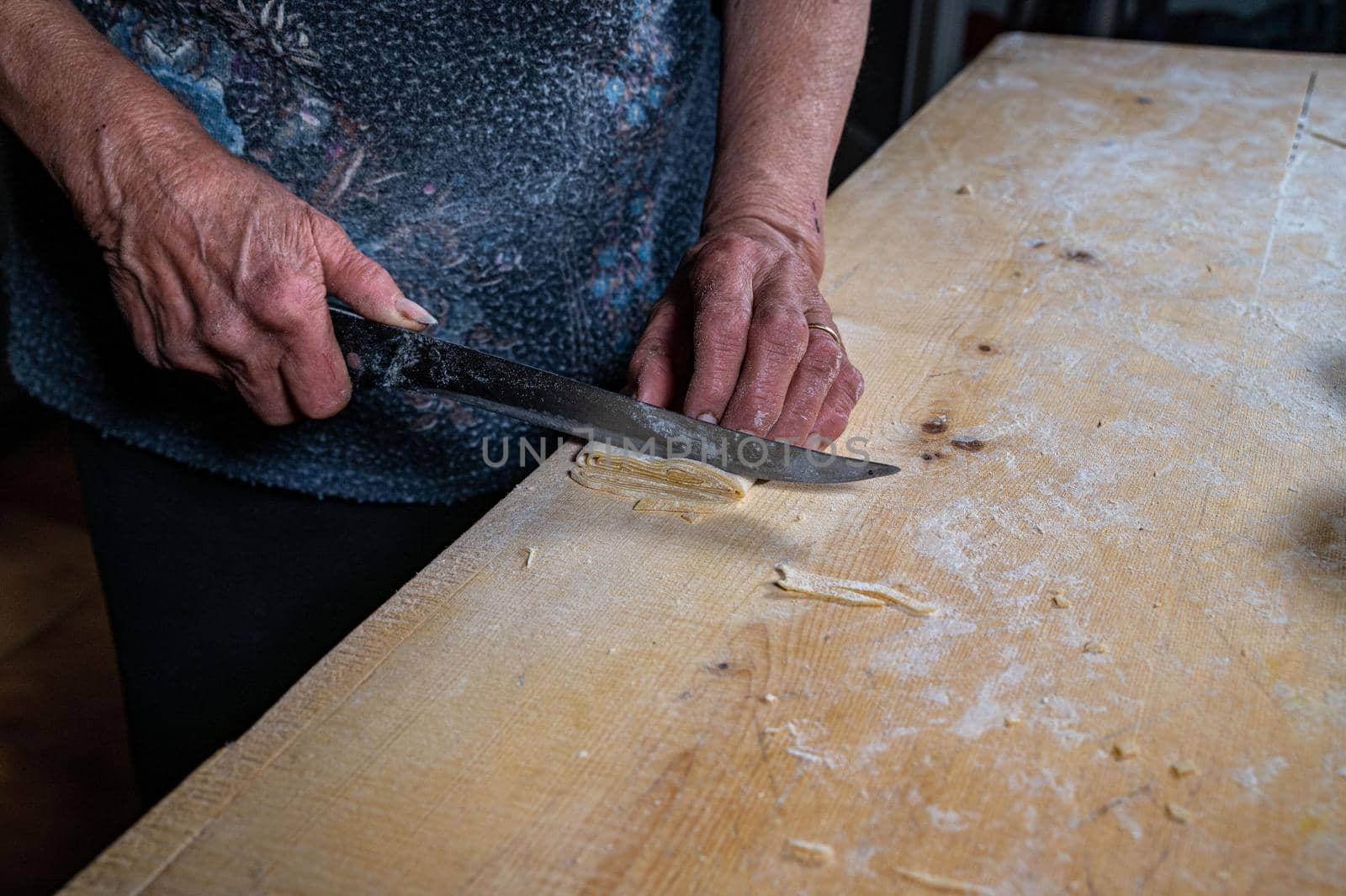 the grandmother prepares homemade egg pasta noodles