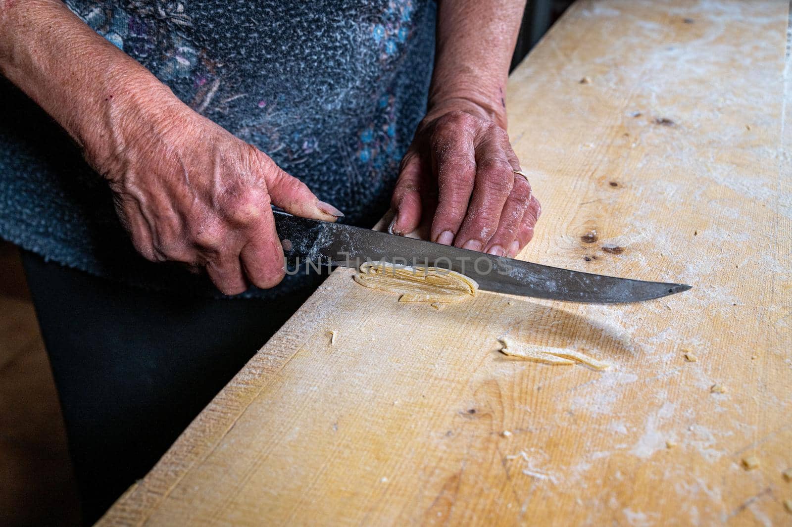the grandmother prepares homemade egg pasta noodles