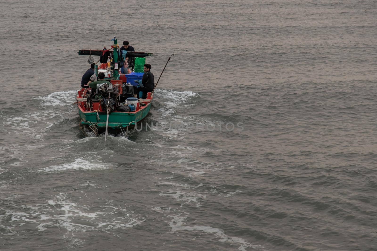 Phetchaburi,Thailand - Mar 15, 2020 : The fisherman and wooden fishing boat used as a vehicle for finding fish in the sea. Selective focus.
