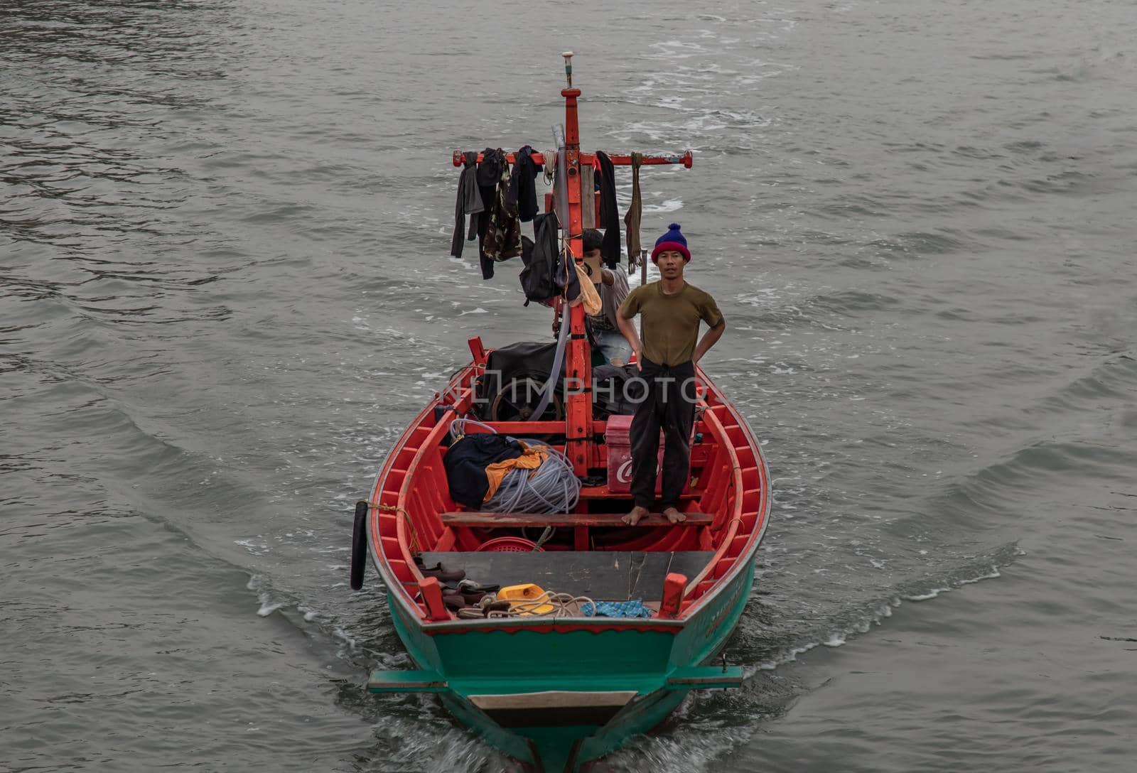 Phetchaburi,Thailand - Mar 15, 2020 : The fisherman and wooden fishing boat used as a vehicle for finding fish in the sea. Selective focus.
