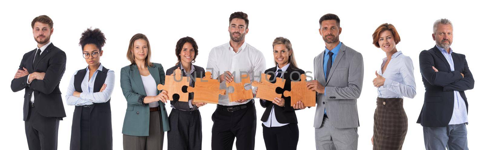 Group of business people standing together in a row holding pieces of a puzzle - isolated on white background