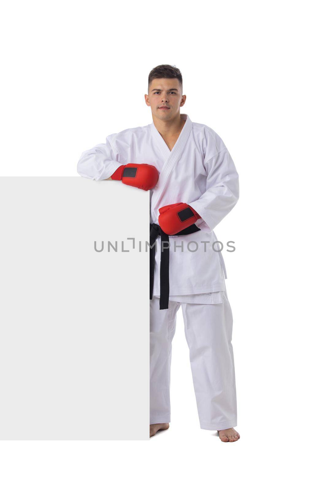 Man fighter training taekwondo with blank banner isolated on white background