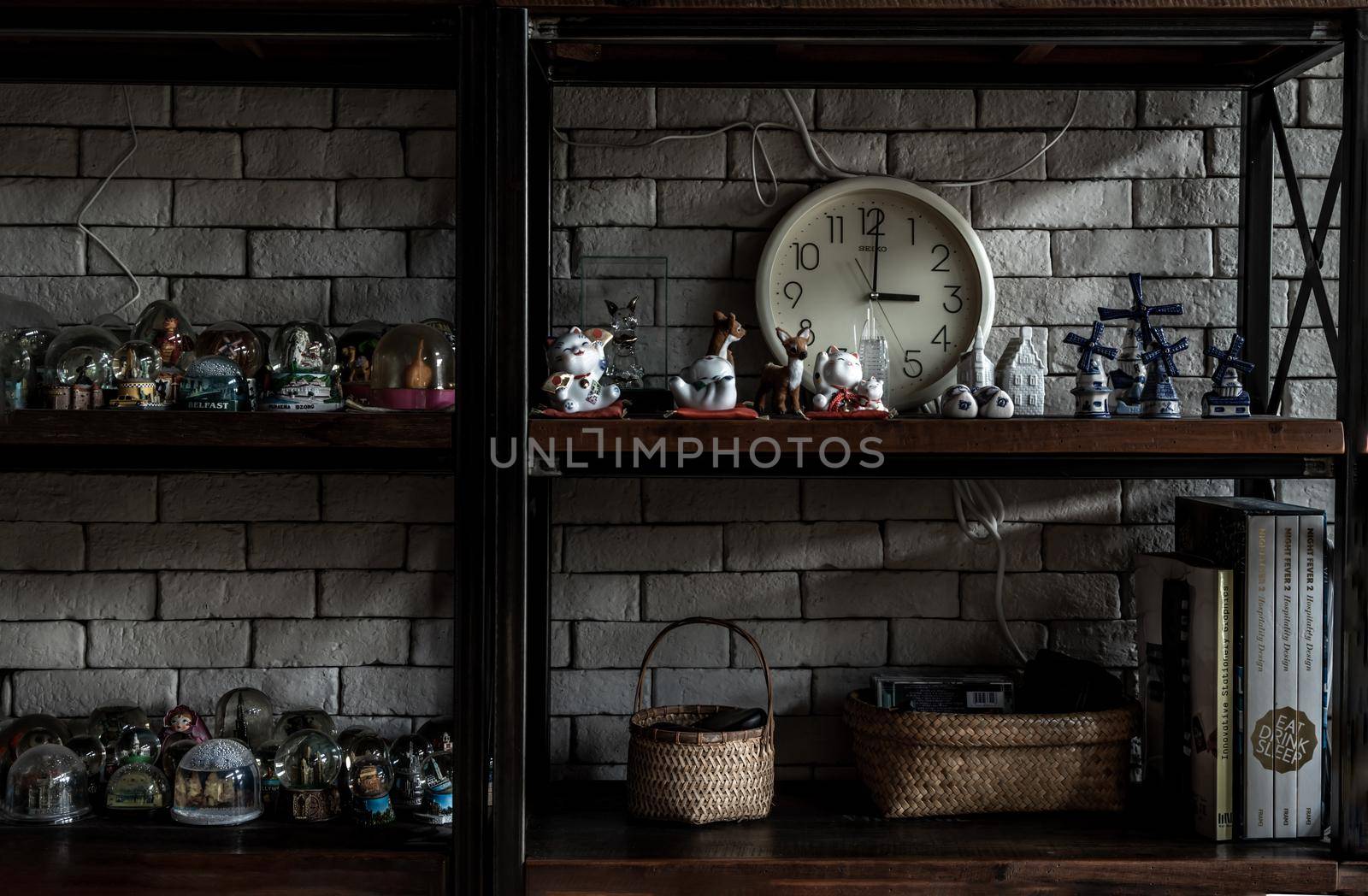 Bangkok, Thailand - 15 Dec 2019 : Souvenir and collectible objects from different cities of the world on books shelf in loft style home.