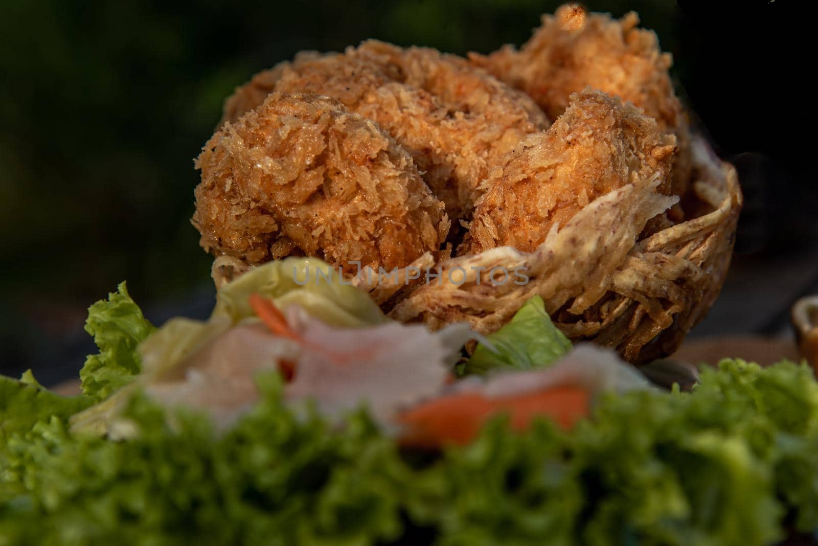 Close-up of Deep-fried shrimp cakes (Tod Mun Goong) and vegetable with chili sauce on wooden background, Thai cuisine.