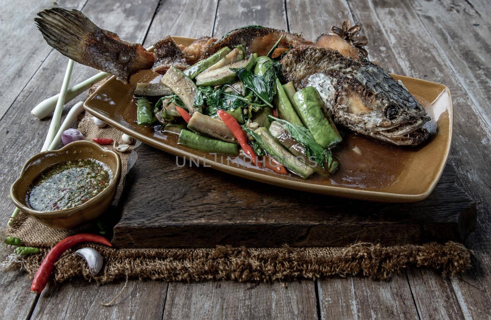 Deep fried whole Snakehead with Spicy stir fry eggplant, Thai food for health.