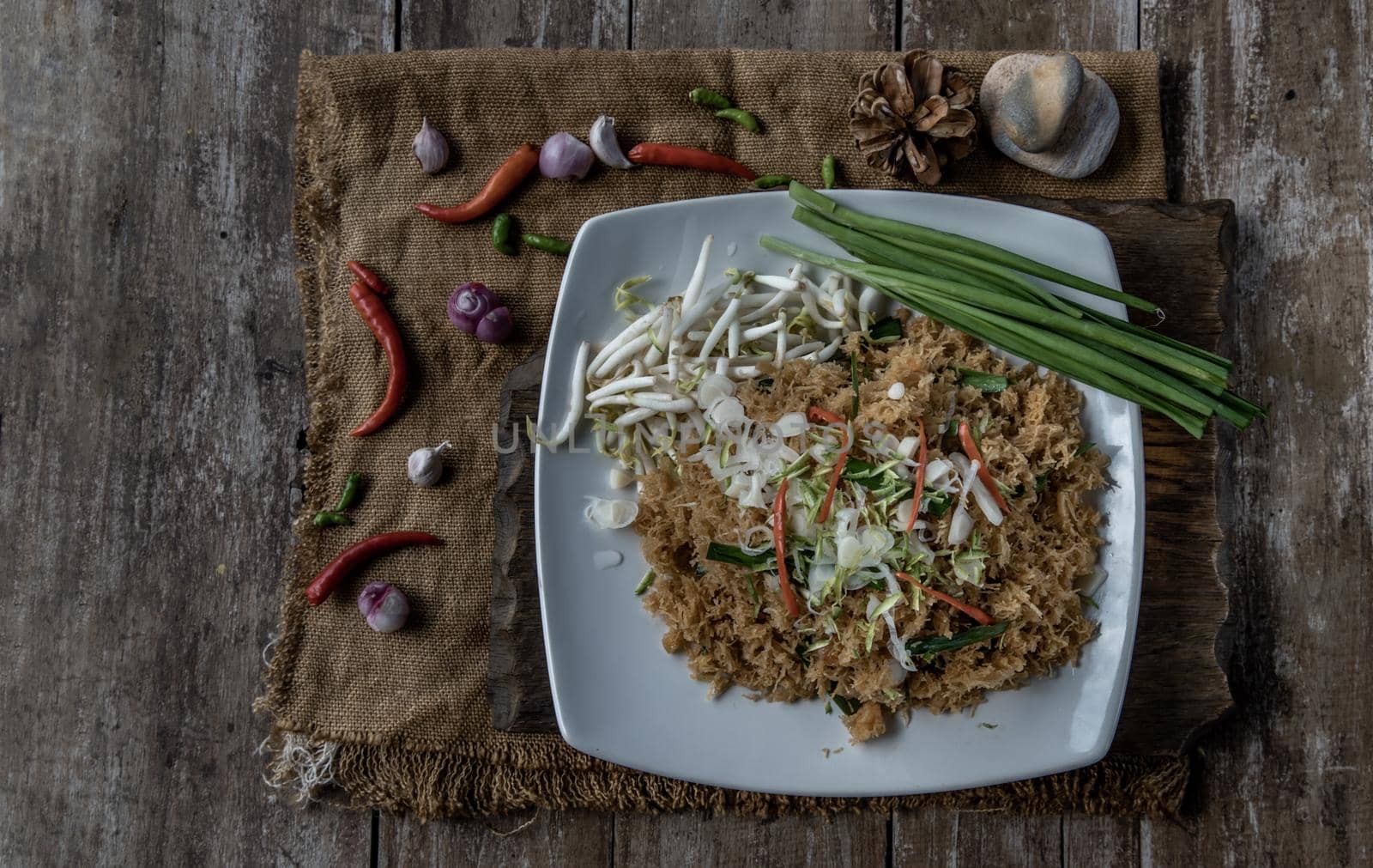 Asian eating food, Mee Grob is an sweet and sour crispy noodles, made from Thai rice noodle with sweet and sour sauce on white plate, Sweet & Sour Crispy Rice Noodles, Top view.