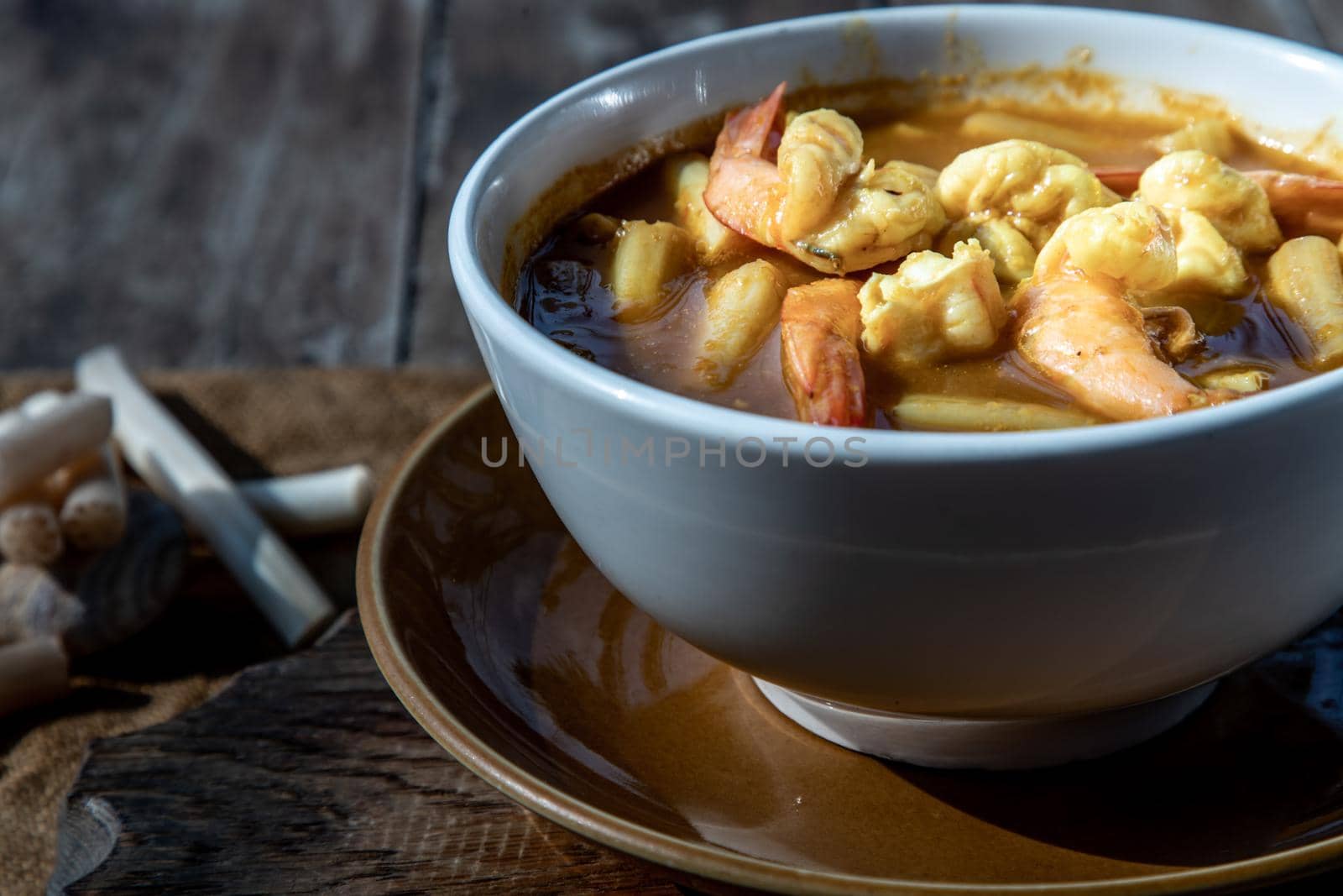 Sour soup with lotus stem and shrimps (kaeng som koong with lotus stem), Traditional Thai food, Oblique view from the top.