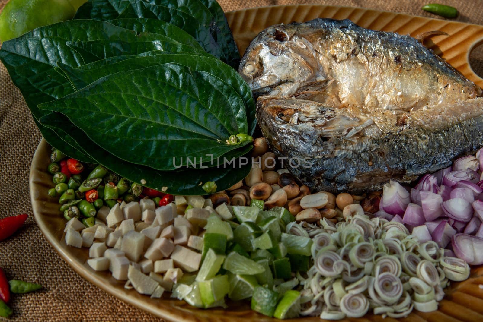 Thai Traditional Food : Fried mackerel served with fresh vegetable and herb, This food is thai food call Meuang Mackerel (Maing-Pla-too) menu.