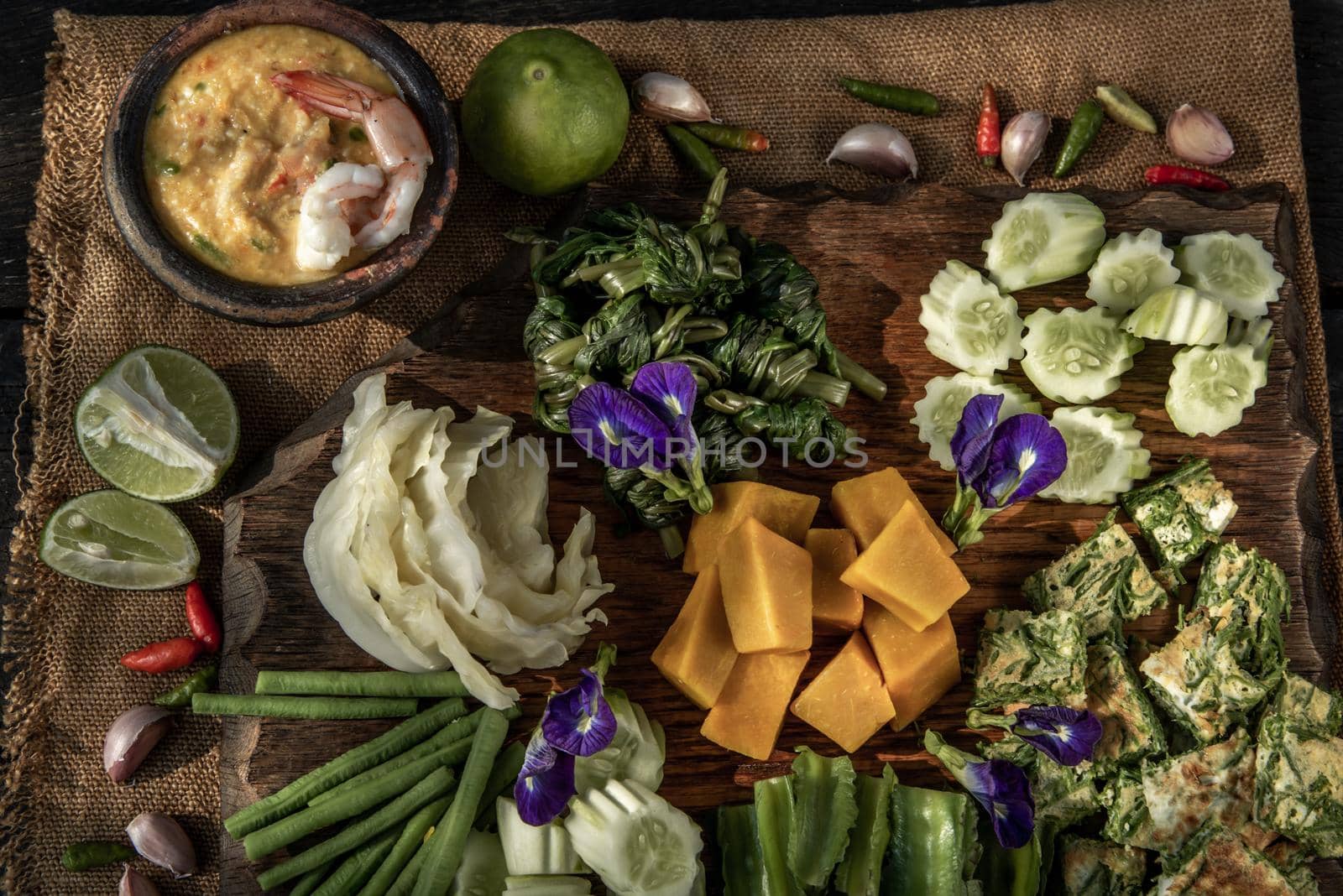 Thai Traditional Local Food : Shrimps chili dip or nam prik with shrimps (Nam Prik Goong Sod) with blanched vegetables and cha-om omelets on wooden backgroud.