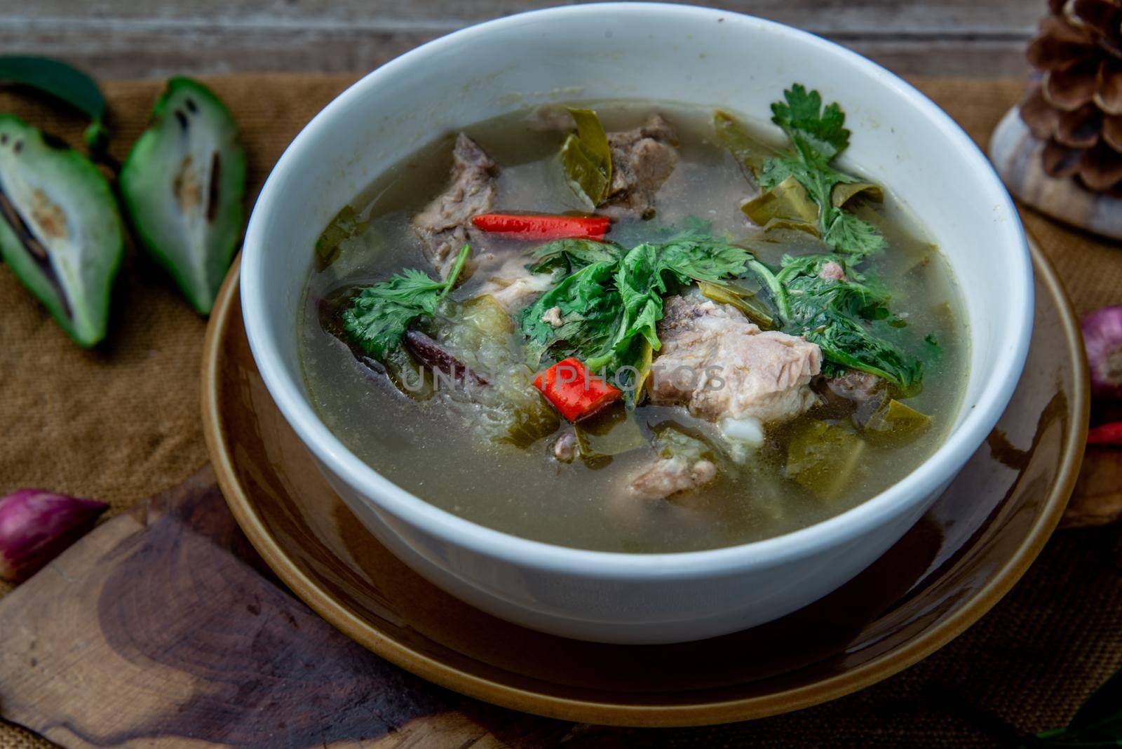 Pork spare rip Madan soup (Kra Dook Moo Tom Ma-Dun) in a white bowl, Traditional Thai food, Oblique view from the top.