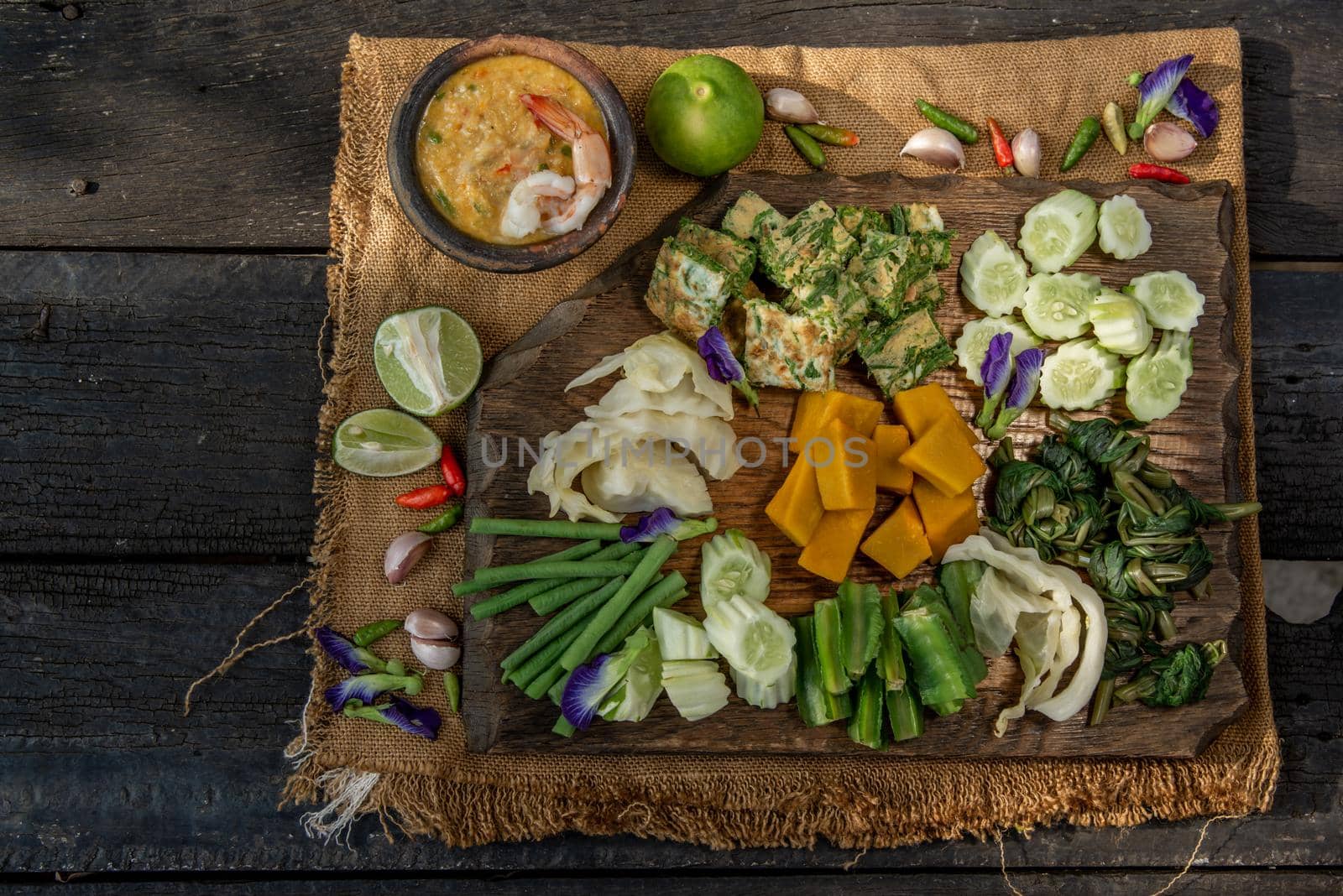 Thai Traditional Local Food : Shrimps chili dip or nam prik with shrimps (Nam Prik Goong Sod) with blanched vegetables and cha-om omelets on wooden backgroud.