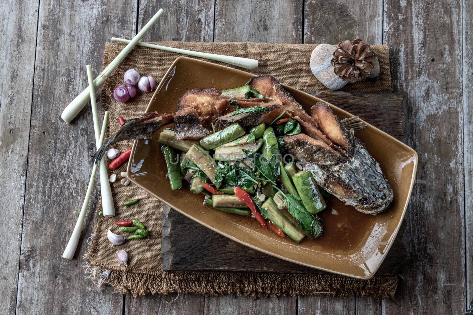 Deep fried whole Snakehead with Spicy stir fry eggplant, Thai food for health.