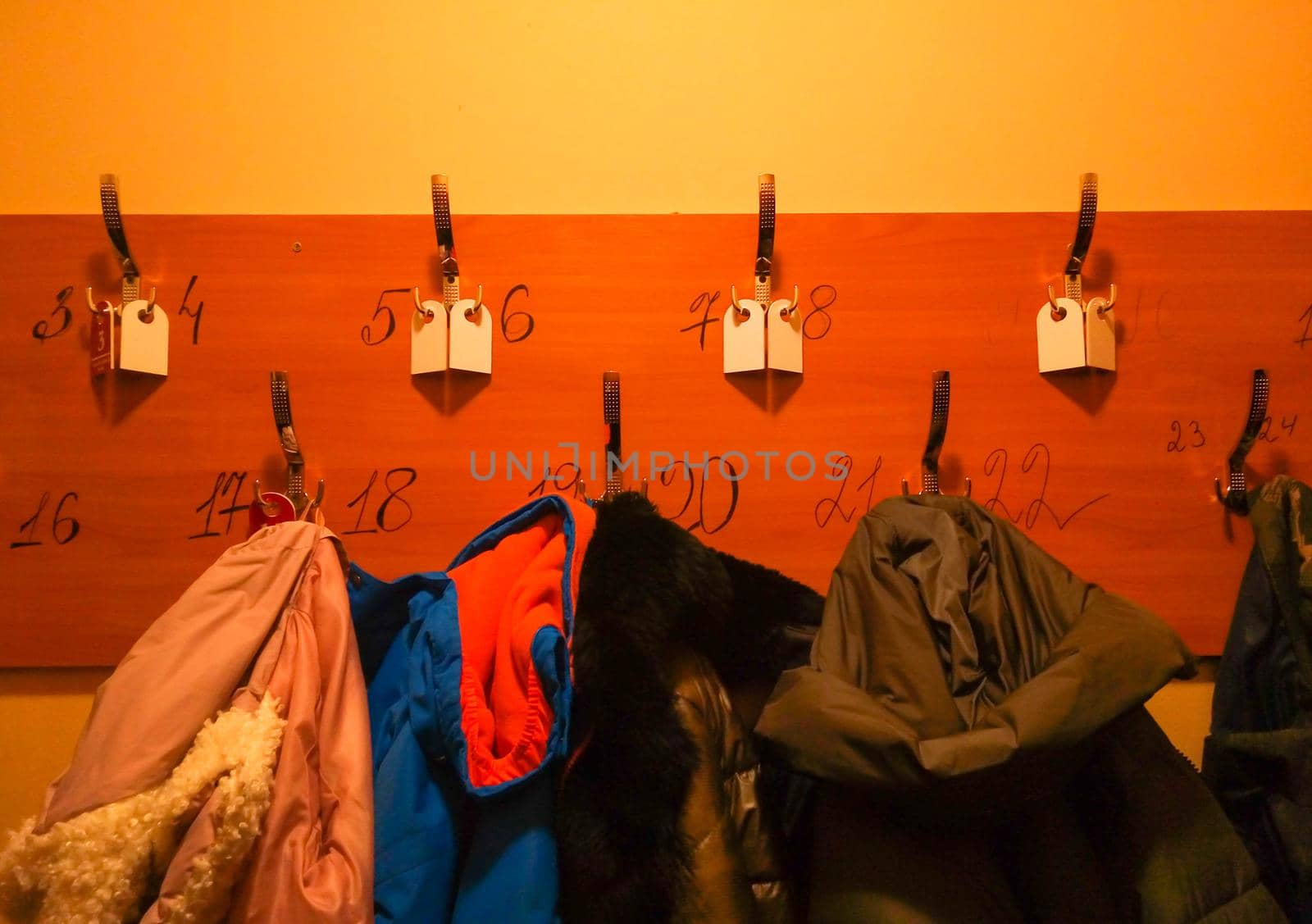 Wooden hanger with hooks and numbers for clothes.