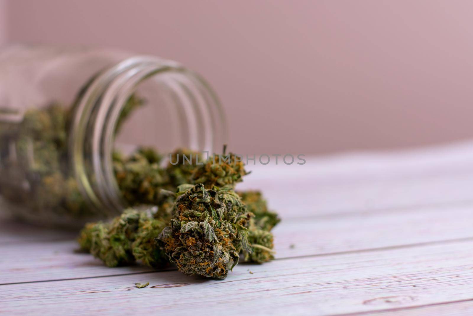 A Glass Jar With Colorful Cannabis Nugs Pouring Out of It by bju12290