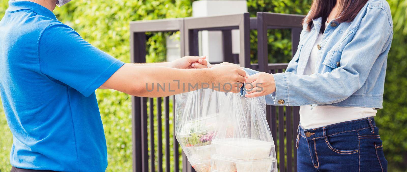 Delivery man making grocery giving rice food boxes plastic bags to woman customer receiving by Sorapop