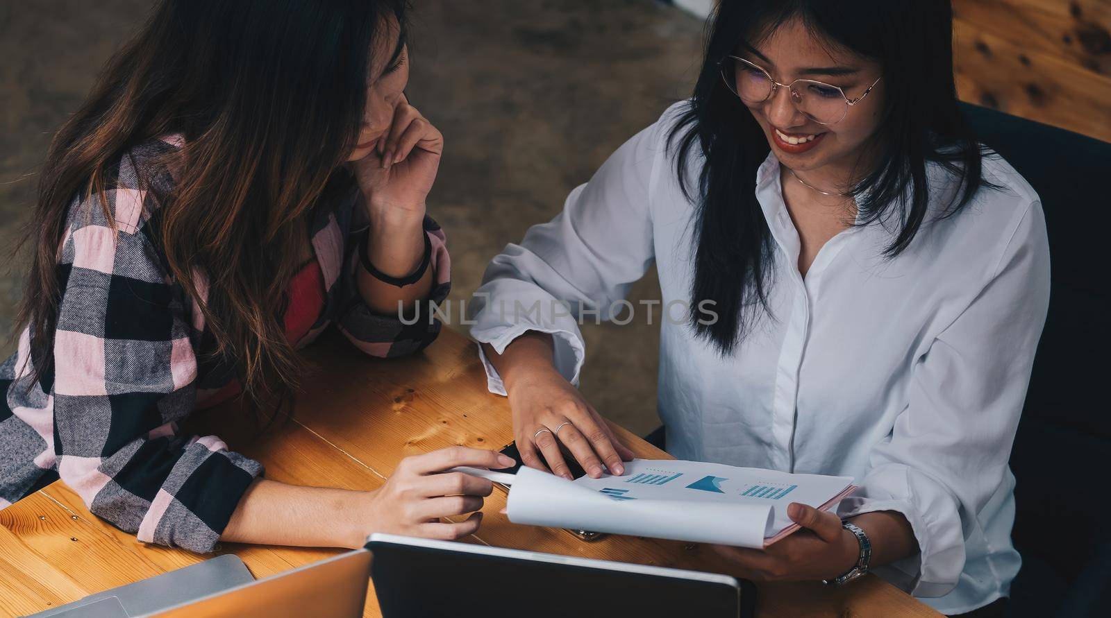 Two businesswomen discussing for financial chart report in office