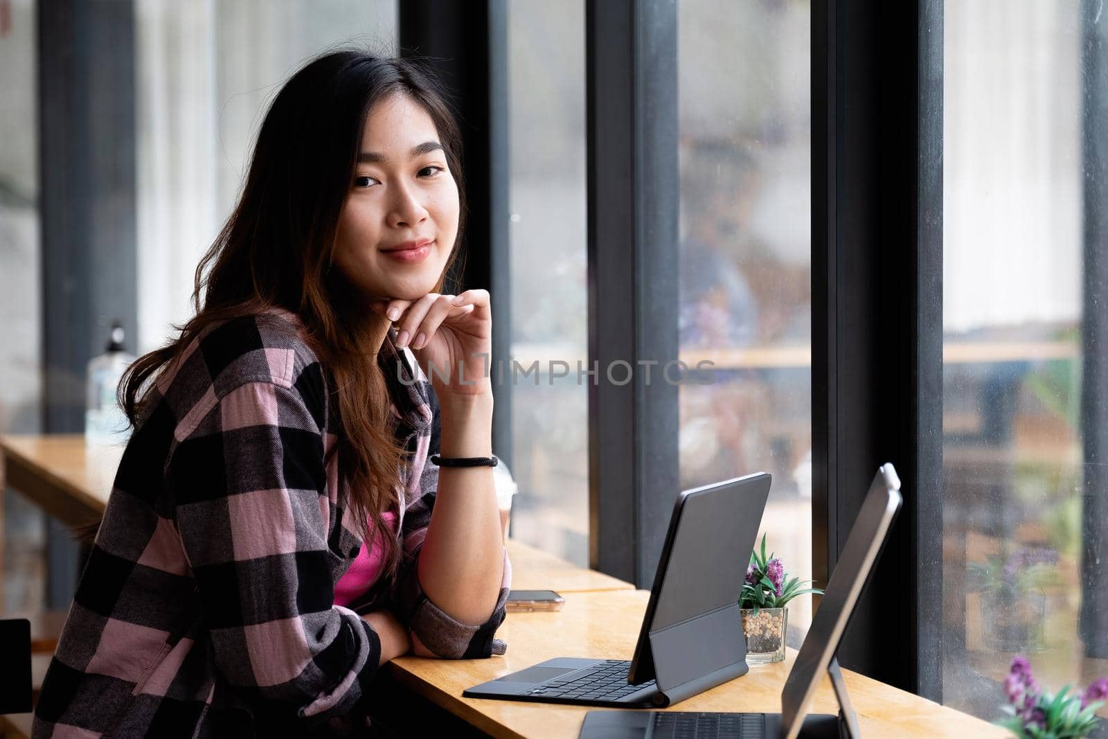 Portrait young asian creative working at cafe with digital tablet.