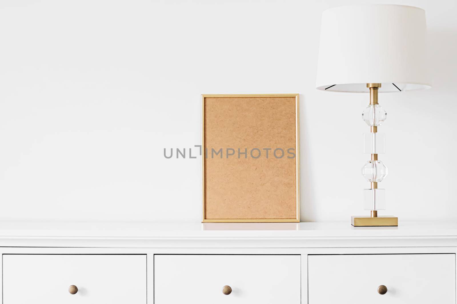 Golden vertical frame for art, poster or photo in white interior, home decor concept