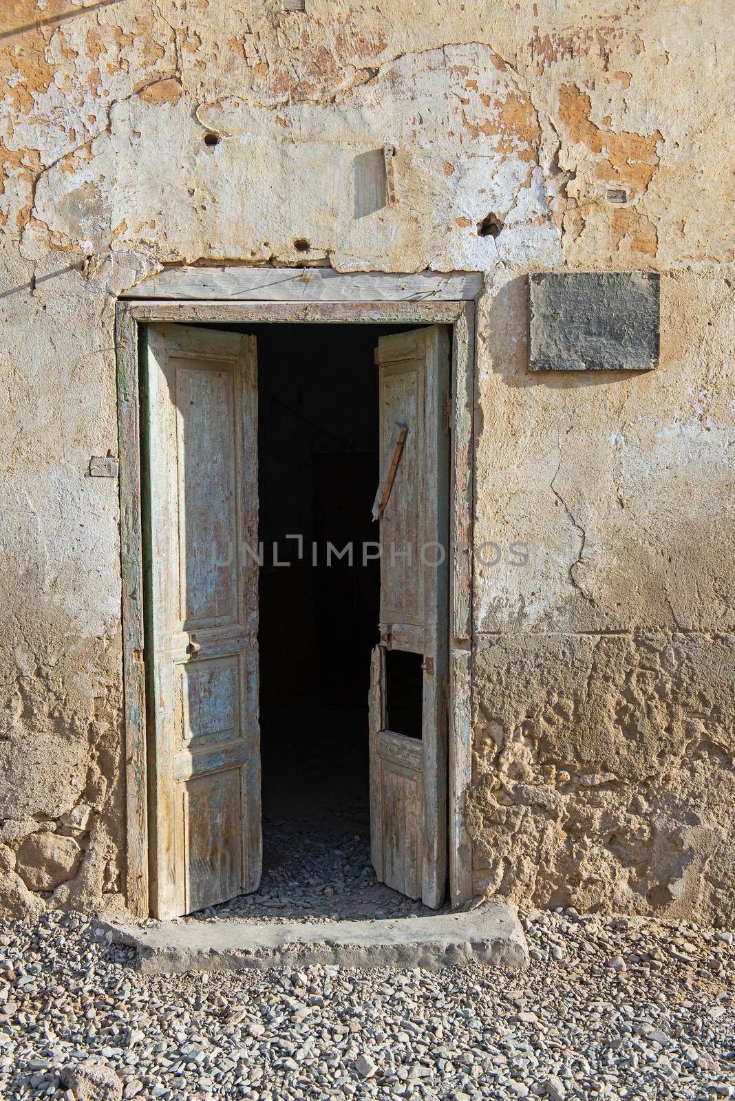 Old rustic wooden door in wall of abandoned traditional egyptian house