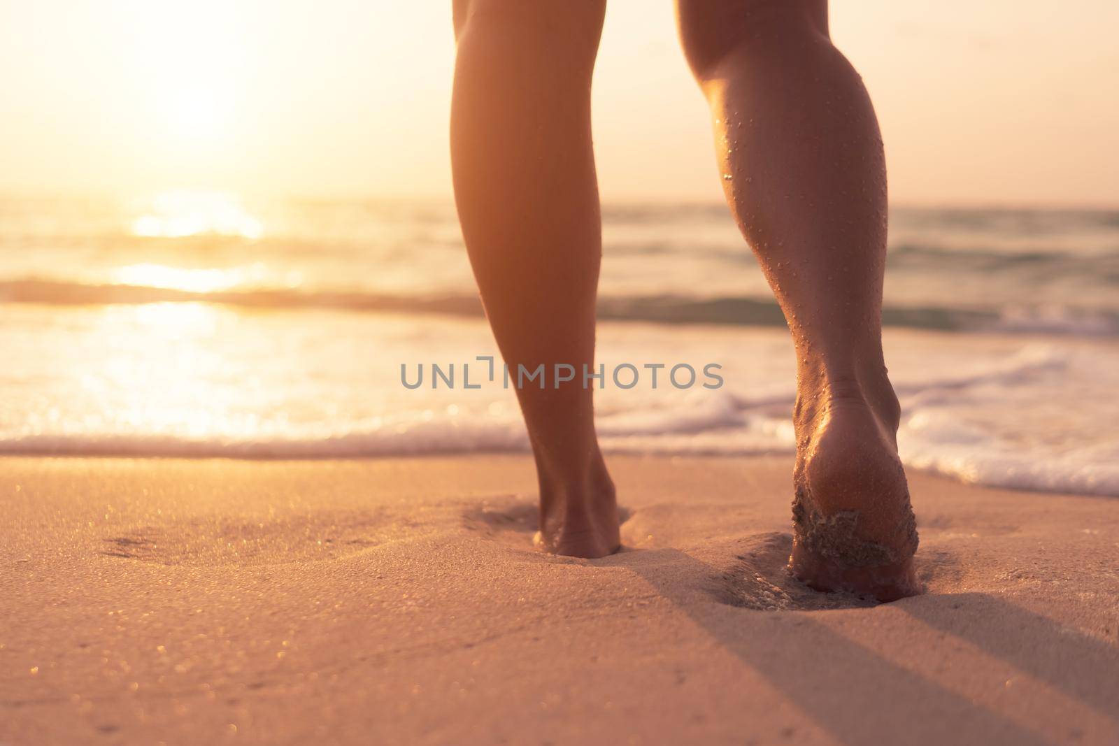 Woman feet walk slow life and relax on sand tropical beach with blue sky background.