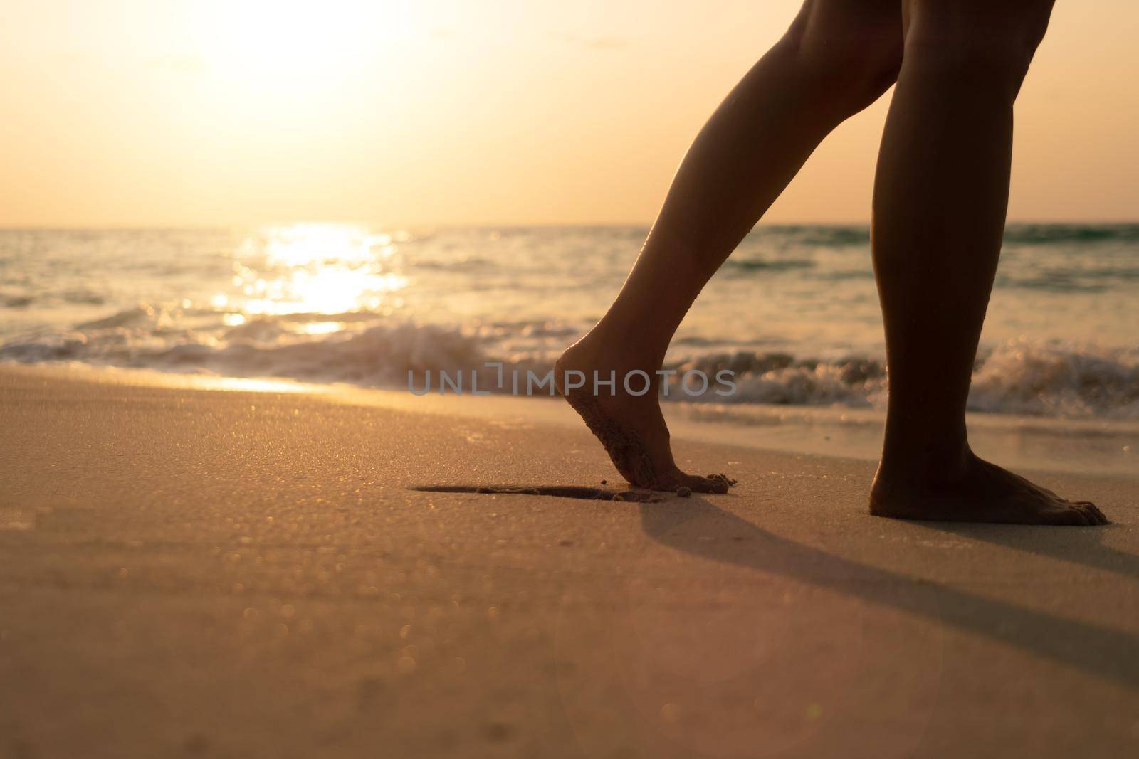 Woman feet walk slow life and relax on sand tropical beach with blue sky background.