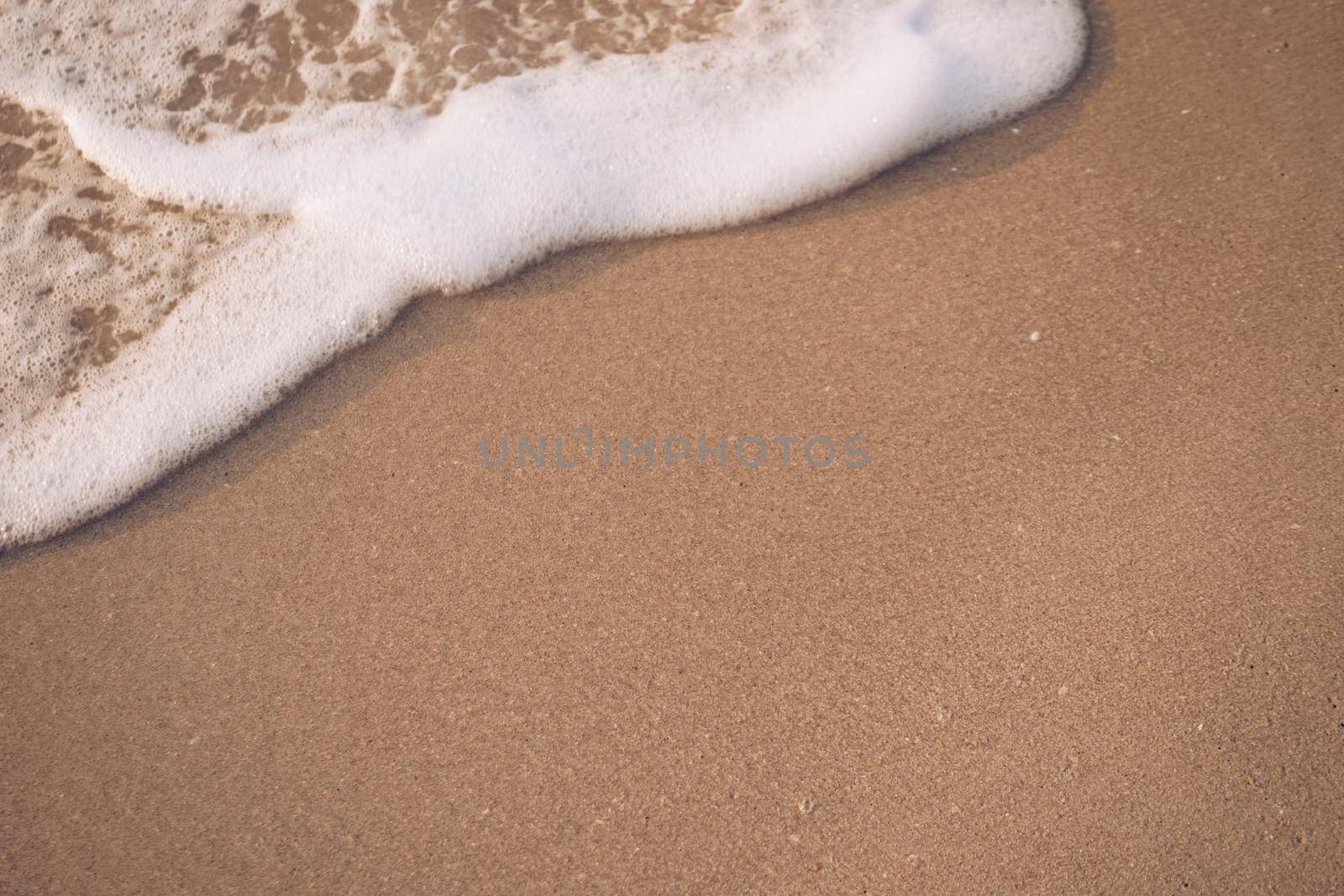 Top view of sand and sea water splash with copy space at tropical clean summer beach.