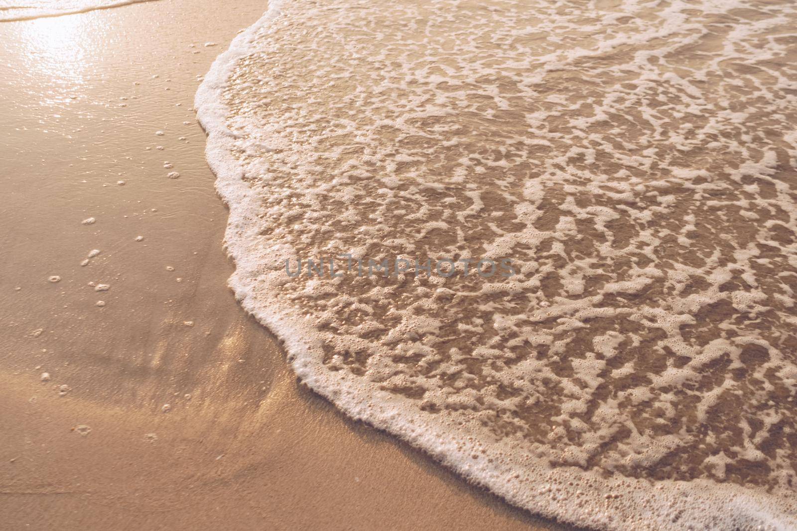 Top view of sand and sea water splash with copy space at tropical clean summer beach.