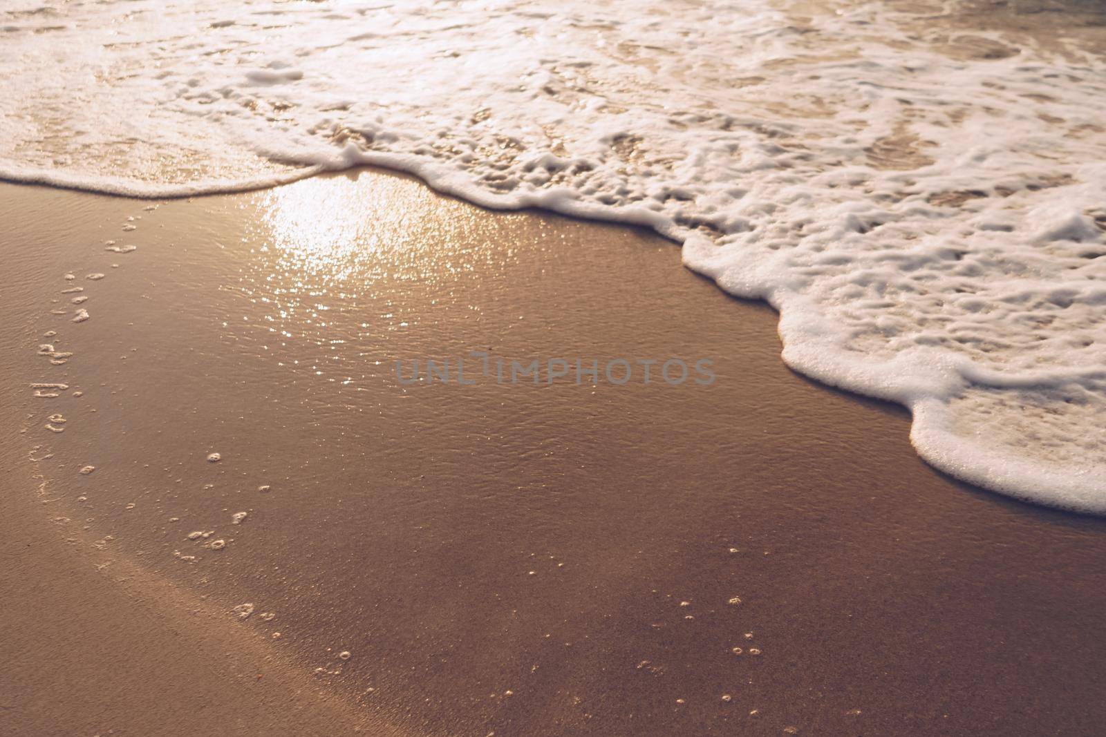 Top view of sand and sea water splash with copy space at tropical clean summer beach.