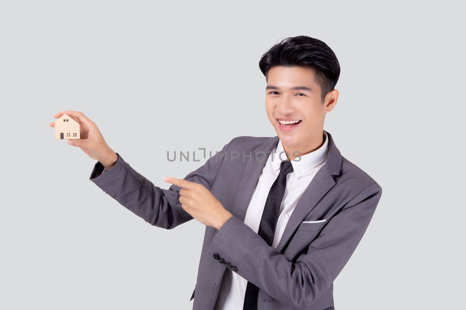 Young asian business man holding the home symbol of saving for future, insurance agent and credit, ownership house, debt and loan of finance, purchase home and refinance, investment real property.