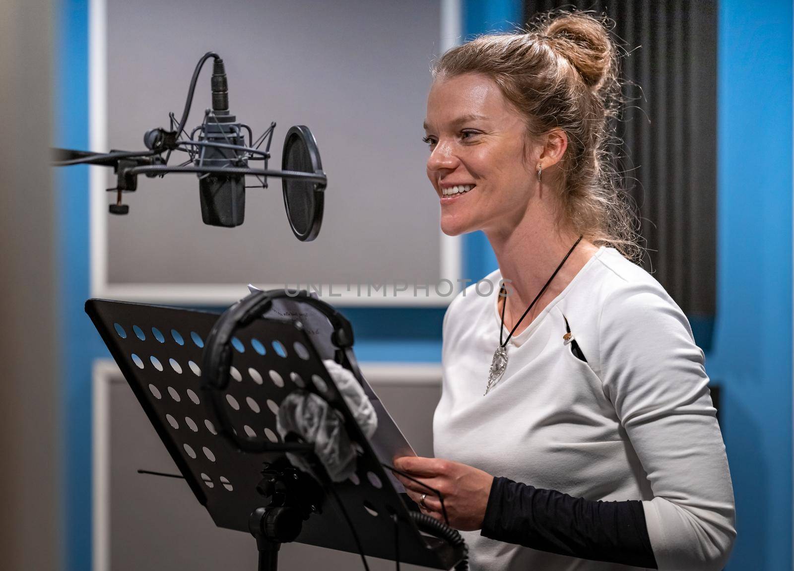 woman recording voice speech, voiceover and singing in studio.